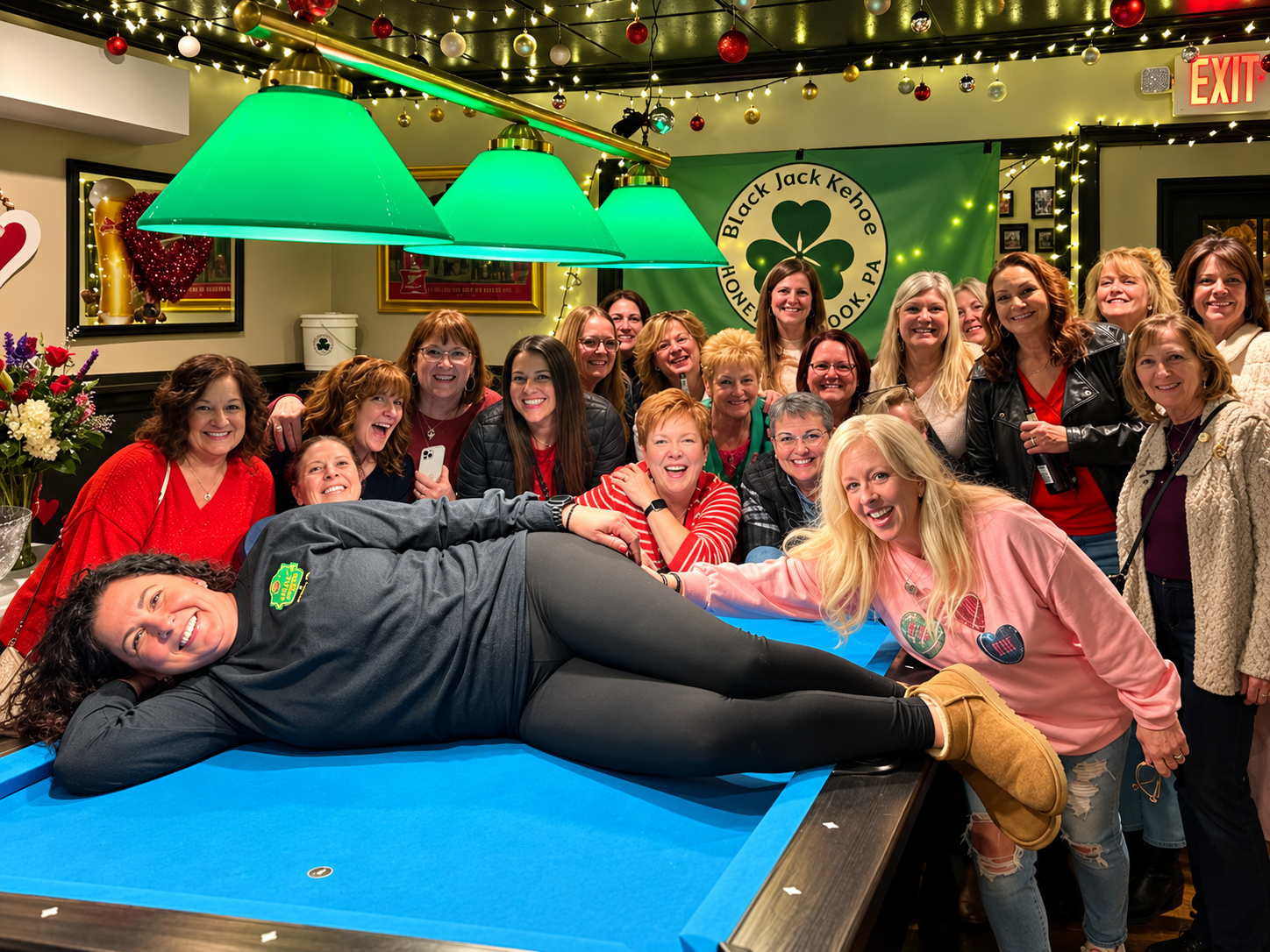 Friends celebrating around the pool table at Kelly's Corner